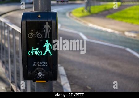 Ein grünes Licht auf einer Fußgängerübergangstaste zeigt dies an Es ist sicher zu überqueren Stockfoto