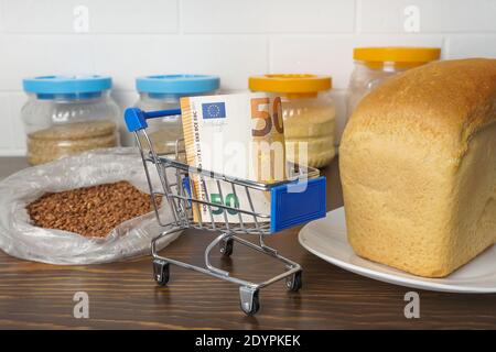 50 Euro in einem Lebensmittelkorb mit Buchweizen, Brot und Getreide. Steigende Lebensmittelpreise und Lebensmittel in Europa und anderen Ländern. Humanitäre Hilfe Stockfoto