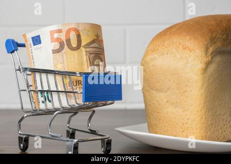 50 Euro in einem Lebensmittelkorb mit Brot. Steigende Lebensmittelpreise und Lebensmittel in Europa und anderen Ländern. Humanitäre Hilfe Stockfoto