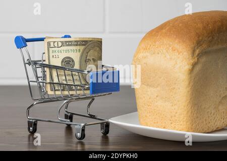 10 Dollar in einem Lebensmittelkorb mit Brot. Steigende Lebensmittelpreise und Lebensmittel in den USA Amerika und anderen Ländern. Humanitäre Hilfe Stockfoto