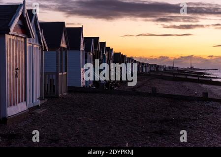 Strandhütten vor Sonnenaufgang am Weihnachtsmorgen in Southend on Sea, Essex, Großbritannien. Lange Reihe von Holzhütten, die sich bis in die Ferne vor Sonnenaufgang erstrecken Stockfoto