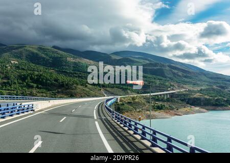 Verlängerter Windsack, der starken Wind anzeigt, auf einem Viadukt über einem Sumpf. Stockfoto