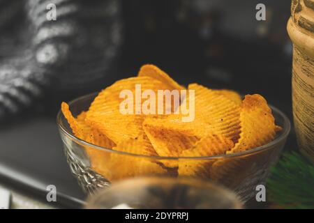 Film zu Hause allein, ungesunde Lebensmittel, Snack, Kartoffelchips in der Schüssel, Laptop, gemütliche Winter Hintergrund Stockfoto