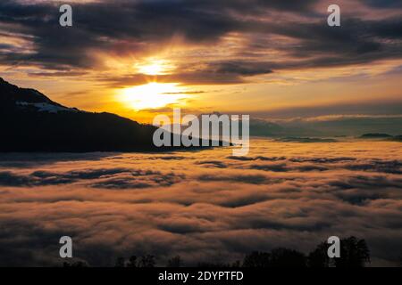 Sonnenuntergang über den Wolken mit Schweizer Bergen im Hintergrund Stockfoto
