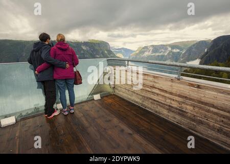 Touristisches Paar mit Fjordblick Aurlandsfjordlandschaft vom Aussichtspunkt Stegastein aus. Norwegen Skandinavien. Nationale touristische Route Aurlandsfjellet Stockfoto