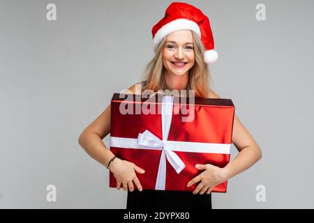 Porträt eines blonden Mädchen in Santa Hut mit Geschenk. Stockfoto