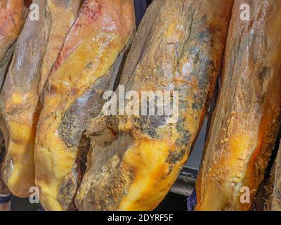 Ganze Beine von gehäutetem spanischen iberischen serrano Schinken (Jamon Serrano) In einem Geschäft hängen Stockfoto