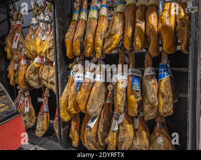 Ganze Beine von gehäutetem spanischen iberischen serrano Schinken (Jamon Serrano) In einem Geschäft hängen Stockfoto