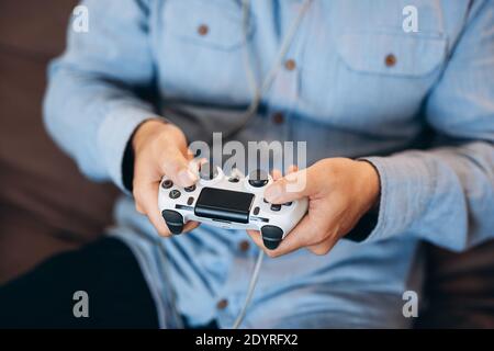 Man's Hands halten Game Controller. Nahaufnahme. Gute Zeit am Wochenende Konzept. Schnittansicht der männlichen Hände. Erwachsene Mann spielt Videospiele zu Hause. Lässig Stockfoto