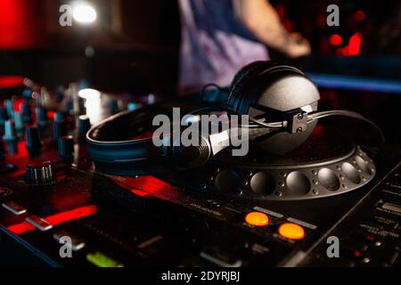DJ hat Pause in der Musiksitzung. Nahaufnahme der DISK-Jockey-Konsole oder Plattenspieler mit Kopfhörern darauf. Mischanlagen. Club-Leben Stockfoto