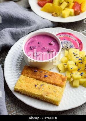 Mangobrot mit Joghurt auf pflanzlicher Basis und frischen Früchten, helle Farben, farbenfrohe Mahlzeit, 45 Grad Winkel Stockfoto