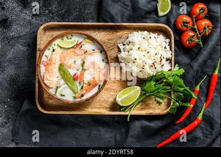 Hausgemachter Tom Kha Gai. Kokosmilchsuppe in einer Schüssel. Thailändisches Essen. Schwarzer Hintergrund. Draufsicht Stockfoto