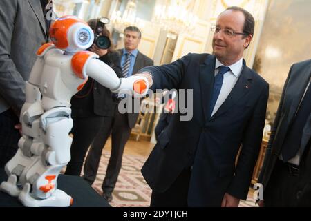 Frankreichs Präsident Francois Hollande hält einen humanoiden Roboter "Nao" von Aldebaran Robotics, als er am 12. September 2013 eine Ausstellung über französisches Industriedesign und Technologie im Elysee Palace in Paris, Frankreich, besucht. Foto von Thierry Orban/ABACAPRESS.COM Stockfoto