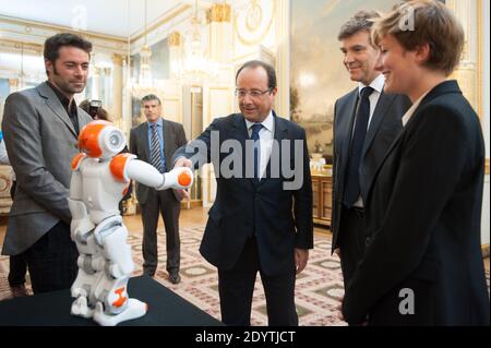 Frankreichs Präsident Francois Hollande hält einen humanoiden Roboter "Nao" von Aldebaran Robotics, als er am 12. September 2013 eine Ausstellung über französisches Industriedesign und Technologie im Elysee Palace in Paris, Frankreich, besucht. Bei R, Französisch Minister für industrielle Erholung Arnaud Montebourg. Foto von Thierry Orban/ABACAPRESS.COM Stockfoto