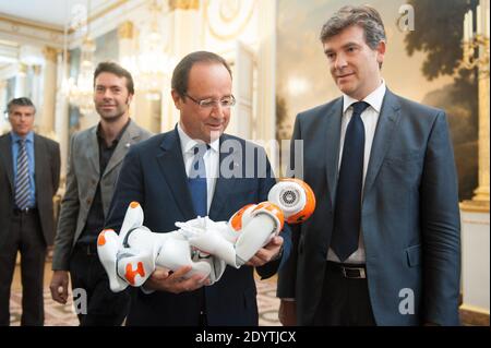 Frankreichs Präsident Francois Hollande hält einen humanoiden Roboter "Nao" von Aldebaran Robotics, als er am 12. September 2013 eine Ausstellung über französisches Industriedesign und Technologie im Elysee Palace in Paris, Frankreich, besucht. Bei R, Französisch Minister für industrielle Erholung Arnaud Montebourg. Foto von Thierry Orban/ABACAPRESS.COM Stockfoto