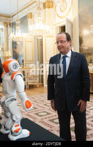 Frankreichs Präsident Francois Hollande hält einen humanoiden Roboter "Nao" von Aldebaran Robotics, als er am 12. September 2013 eine Ausstellung über französisches Industriedesign und Technologie im Elysee Palace in Paris, Frankreich, besucht. Foto von Thierry Orban/ABACAPRESS.COM Stockfoto