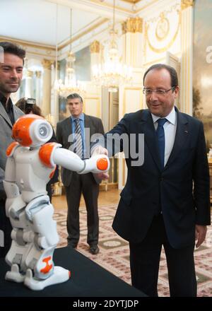 Frankreichs Präsident Francois Hollande hält einen humanoiden Roboter "Nao" von Aldebaran Robotics, als er am 12. September 2013 eine Ausstellung über französisches Industriedesign und Technologie im Elysee Palace in Paris, Frankreich, besucht. Foto von Thierry Orban/ABACAPRESS.COM Stockfoto