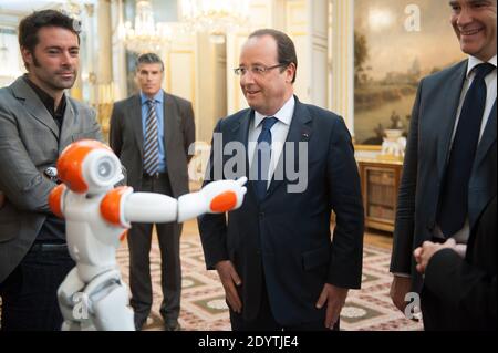 Frankreichs Präsident Francois Hollande hält einen humanoiden Roboter "Nao" von Aldebaran Robotics, als er am 12. September 2013 eine Ausstellung über französisches Industriedesign und Technologie im Elysee Palace in Paris, Frankreich, besucht. Bei R, Französisch Minister für industrielle Erholung Arnaud Montebourg. Foto von Thierry Orban/ABACAPRESS.COM Stockfoto