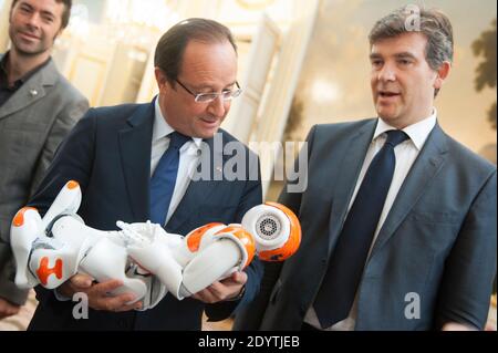 Frankreichs Präsident Francois Hollande hält einen humanoiden Roboter "Nao" von Aldebaran Robotics, als er am 12. September 2013 eine Ausstellung über französisches Industriedesign und Technologie im Elysee Palace in Paris, Frankreich, besucht. Bei R, Französisch Minister für industrielle Erholung Arnaud Montebourg. Foto von Thierry Orban/ABACAPRESS.COM Stockfoto