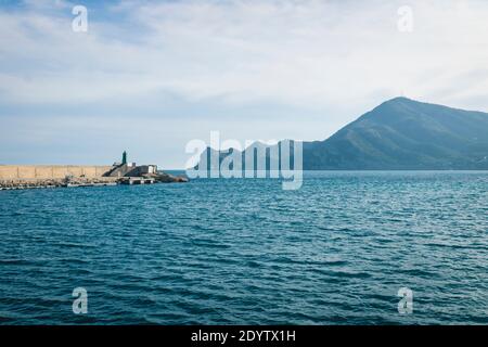 Leuchtturm am Hafen von Altea mit Blick auf Meer und Bergkette an einem sonnigen Tag, Altea, Costa Blanca, Spanien Stockfoto