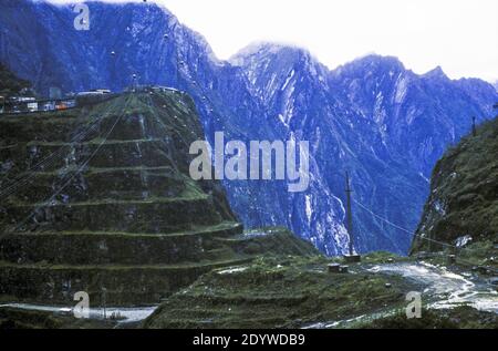 Offene Arbeiten in PT Freeport Indonesiens reichem Grasberg Gold- und Kupferbergwerk in den Bergen von West-Papua, Indonesien. Der Ertsberg, der 1936 vom niederländischen Abenteurer Jean-Jacques Douzy entdeckt wurde, wurde von der Landkarte gerissen und durch eine tiefe Grube mit einem Erbsensuppensee ersetzt. Der Grasberg, ein weiterer Kupferberg, wird ständig durch eine gespenstische Stufenpyramide ersetzt. (2000) Stockfoto