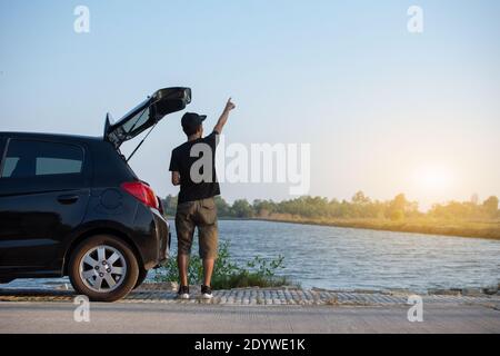 Menschen stehen am Auto geparkt auf der Straße Stockfoto