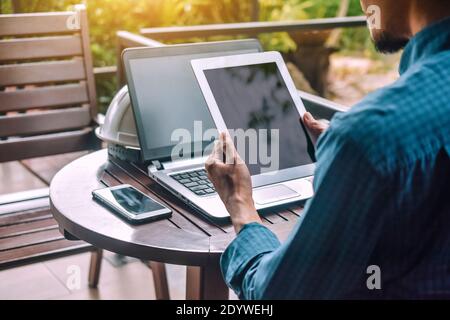 Geschäftsmann Holding Tablet Handy Smartphone Notebook auf Tisch für Arbeiten Stockfoto