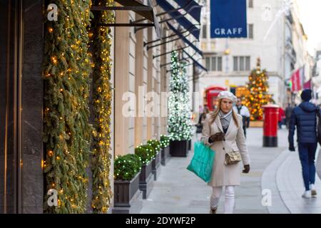 London, Großbritannien. Dezember 2020. Shopper gehen vorbei an Weihnachtsdekorationen in New Bon Street.unter Tier vier Einschränkungen, Pubs und Restaurants schließen, sowie ‘nicht-wesentliche' Einzelhandel. Kredit: SOPA Images Limited/Alamy Live Nachrichten Stockfoto