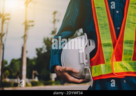 Engineering hält weiß Sicherheit Hüte und elektrische Pole Hintergrund Stockfoto