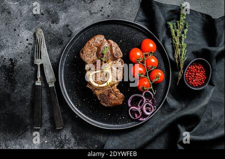 Osso Buco, gekochter Kalbsschenkel. Ossobuco-Fleisch. Schwarzer Hintergrund. Draufsicht Stockfoto