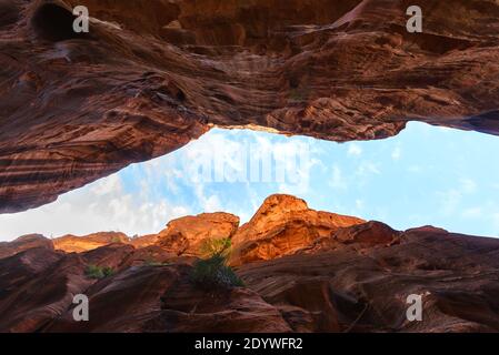 Petra Zufahrtsroute bekannt als Siq. Gerader Blick auf den schmalen Durchgang zwischen riesigen und hohen Sandsteinfelsen und Himmel. Tor zum Siq in Petra, Jordanien. Stockfoto