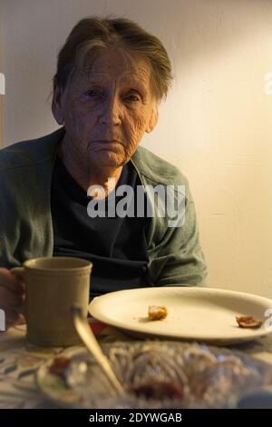 Eine 84-jährige Frau, die an Depressionen leidet und eine Tasse Kaffee trinkt. Stockfoto