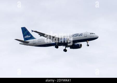 New York, Usa. Dezember 2020. Ein Jet Blue Airbus A320-232 landet auf dem John F. Kennedy International Airport (JFK) in New York City.Gouverneur Andrew Cuomo gab bekannt, dass drei Fluggesellschaften, die Flüge von Großbritannien nach New York City anbieten, Reisende aus Großbritannien auf eine neue Sorte COVID-19 testen werden. Diese Fluggesellschaften sind Delta, Virgin Airlines und British Airways, und alle haben zugestimmt, dies zu tun. Kredit: SOPA Images Limited/Alamy Live Nachrichten Stockfoto