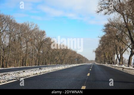 Neue Straße nach Reparatur im Winter. Neue saubere Asphalt auf der Straße gelegt. Stockfoto