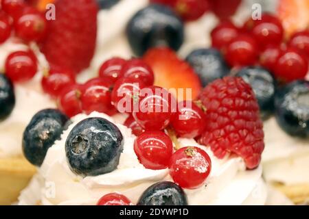 Cremiger Kuchen mit frischen Beeren. Süßes Dessert mit Heidelbeeren, Himbeeren und roten Johannisbeeren Stockfoto