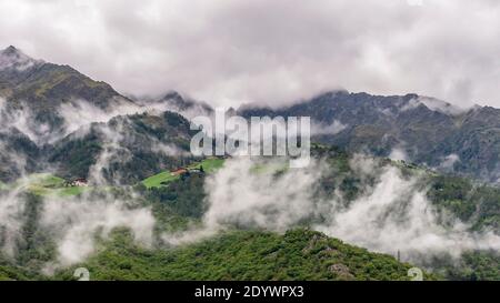Die Alpen oberhalb von Naturns, Südtirol, Italien, teilweise bedeckt von Schichten von tiefen weißen Wolken Stockfoto