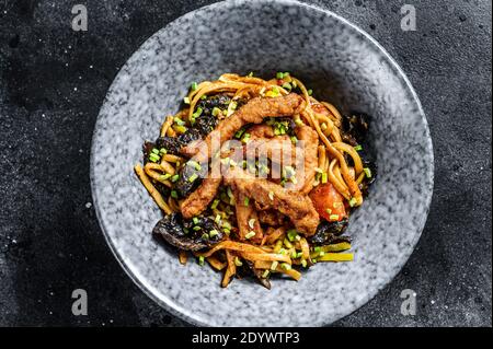 Udon Nudeln mit Huhn und Paprika. Schwarzer Hintergrund. Draufsicht Stockfoto