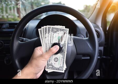 Dollar und den Schlüssel auf der Hand mit dem Auto zum Einkaufen sparen in parament Konzept Stockfoto