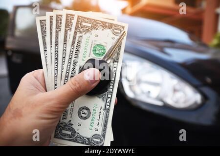 Dollar und den Schlüssel auf der Hand mit dem Auto zum Einkaufen sparen in parament Konzept Stockfoto