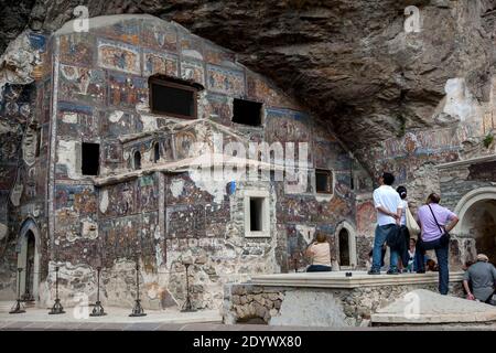 Touristen bewundern die Fresken der Felskirche im Kloster Sumela. Es ist ein griechisch-orthodoxes Kloster aus dem 4. Jahrhundert in der Provinz Trabzon, Türkei. Stockfoto