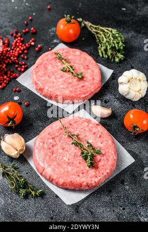 Rohes Hackfleischschnitzel, Hackfleisch und Schweinefleisch. Burger-Patties. Schwarzer Hintergrund. Draufsicht Stockfoto