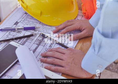 Vorgesetzter überprüft die Blaupause auf der Baustelle des Immobiliengebäudes Stockfoto