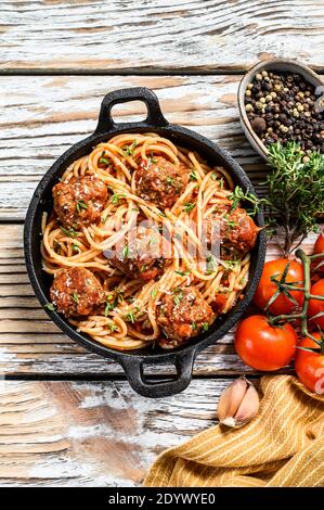 Spaghetti mit Fleischbällchen und Tomatensauce. Weißer Holzhintergrund. Draufsicht Stockfoto
