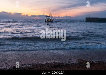 Hastings, East Sussex, Großbritannien 28. Dezember 2020. Hastings-Fischtrawler fahren vom Fischerstrand der Altstadt Stade aus auf das Meer im Ärmelkanal. Mit mehr als 25 Booten verfügt Hastings über die größte am Strand angelaufene Fischereiflotte in Europa. Carolyn Clarke/Alamy Live News Stockfoto