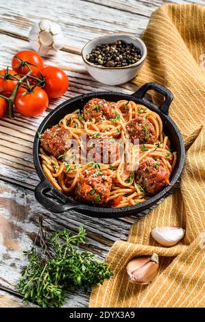 Spaghetti mit Fleischbällchen und Tomatensauce. Weißer Holzhintergrund. Draufsicht Stockfoto