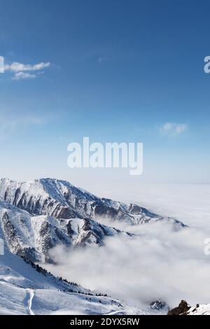 Skigebiet in Wolkig Tian Shan Berggipfel im Nebel in der Nähe von Almaty Stadt. Vertikale Aufnahmen. Stockfoto