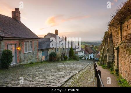 Shaftesbury, Dorset, Großbritannien. Dezember. Wetter in Großbritannien. Ein Blick auf Gold Hill in Shaftesbury in Dorset an einem kalten eisigen Morgen mit winterlichen Duschen kurz nach Sonnenaufgang. Bild: Graham Hunt/Alamy Live News Stockfoto