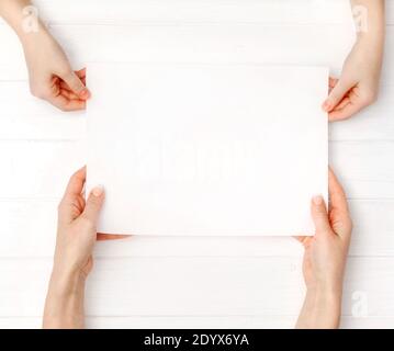 Hände von Mutter und Tochter mit leerem weißem Papier a4 Größe für Design Stockfoto