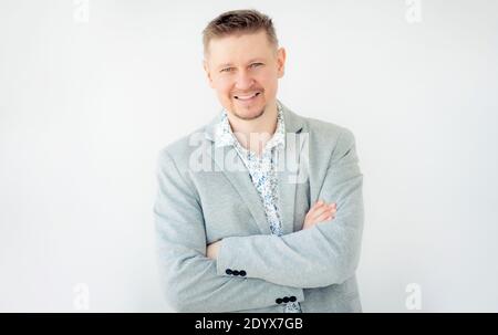 Porträt eines lächelnden jungen Mannes in grauer Jacke isoliert auf Weißer Hintergrund Stockfoto