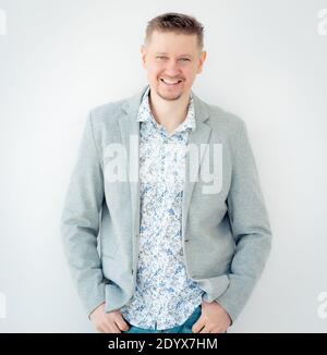 Lächelnder Kerl im floralen Hemd und Jacke isoliert auf weiß Hintergrund Stockfoto